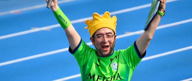 サポーターの声援の中マイクを掲げるスタジアムDJ・三村ロンド